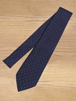 Cravate bleu marine à motifs rouges et blancs